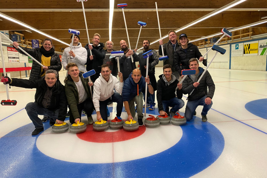 Gruppenfoto Teamausflug Curlin, 2 Reihen, hinten stehend, vorne sitzend, Curling am Boden bei der vorderen Reihen