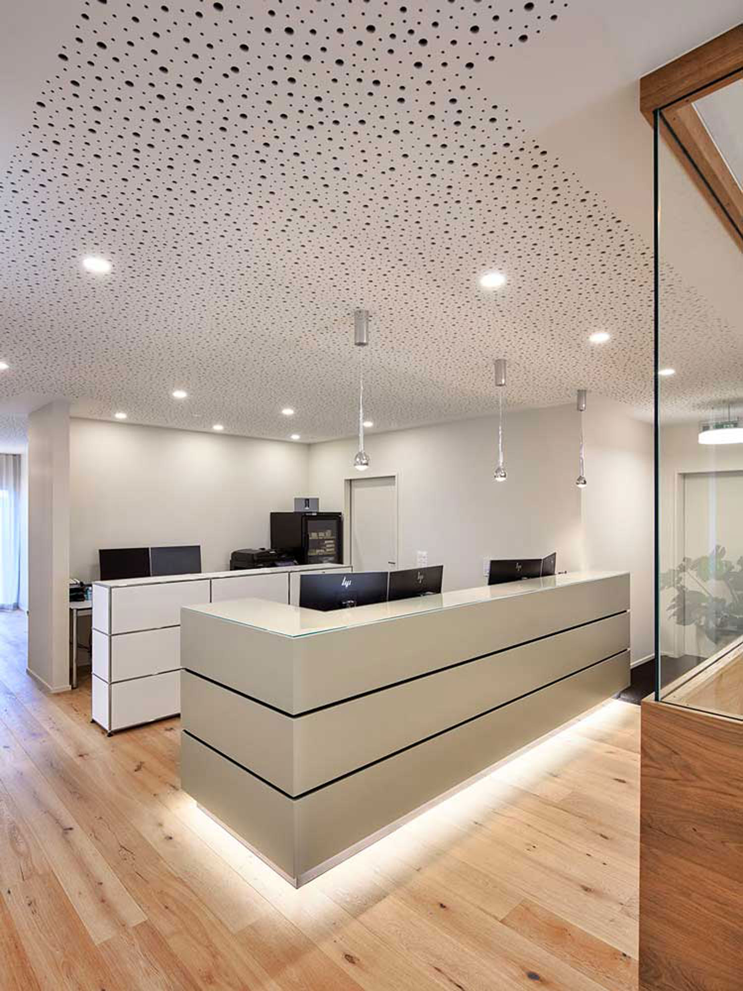 Empfang einer Gesundheitspraxis, leuchtendes Sideboard in grau mit schwarzen schmale Rillen